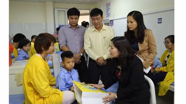 Đại diện Bộ Lao động - Thương binh và Xã hội tặng quà cho trẻ phẫu thuật tại Bệnh viện Răng - Hàm - Mặt Trung ương (Ảnh: NFVC).