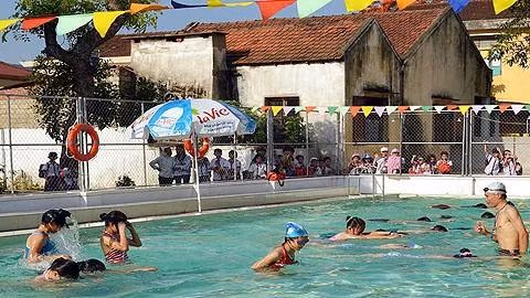 Giáo viên hướng dẫn học sinh tập bơi.