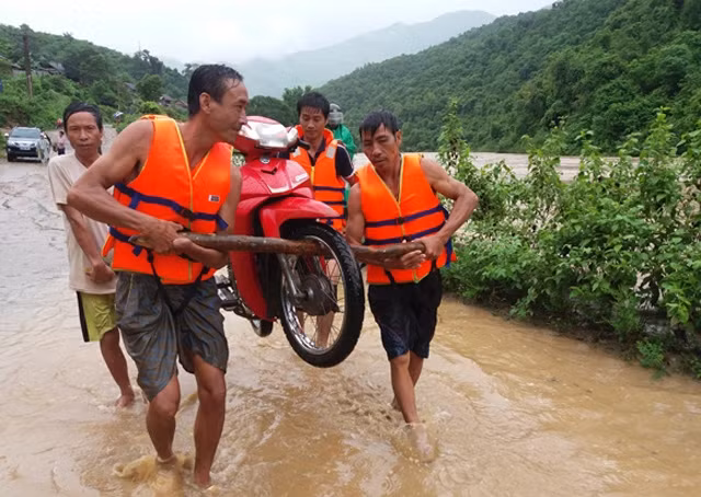 Nước lũ gây ngập nhiều tuyến đường ở huyện Kỳ Sơn, Nghệ An. Người dân di chuyển phương tiện, đồ đạc ra khỏi vùng ngập lụt. Ảnh Báo Nghệ An