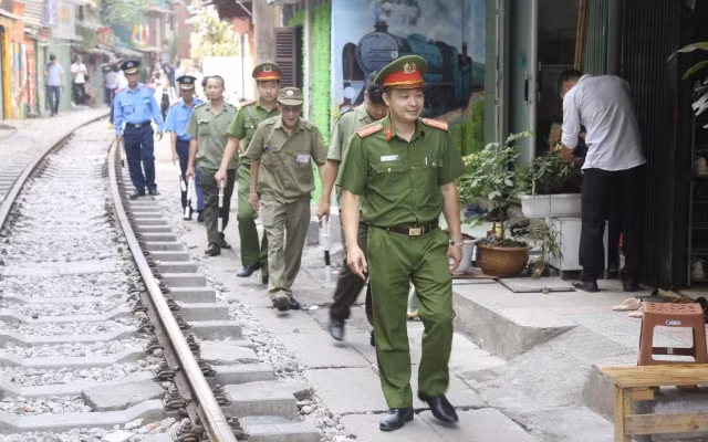 Lực lượng chức năng kiểm tra, nhắc nhở các cửa hàng kinh doanh tại khu vực đường tàu phố Phùng Hưng. (Ảnh: ĐĂNG ANH)