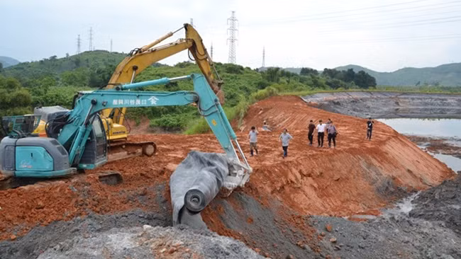 Các lực lượng cứu hộ tích cực thi công đê quây hàn khẩu bờ bao bị vỡ của hồ chứa nước thải của Nhà máy DAP Lào Cai, sáng ngày 9-9- 2018.