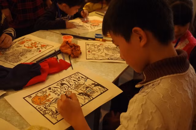 Các em nhỏ hào hứng tham gia in, vẽ tranh dân gian.