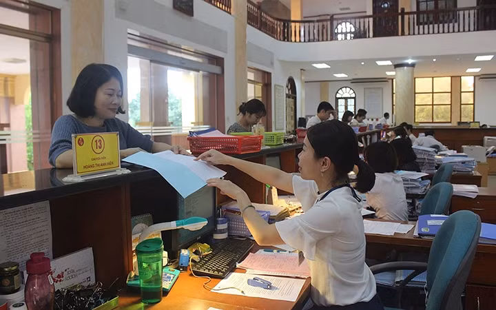 Cán bộ Kho bạc Nhà nước tỉnh Thái Nguyên hướng dẫn khách hàng thực hiện các thủ tục hành chính. Ảnh: Thu Hằng