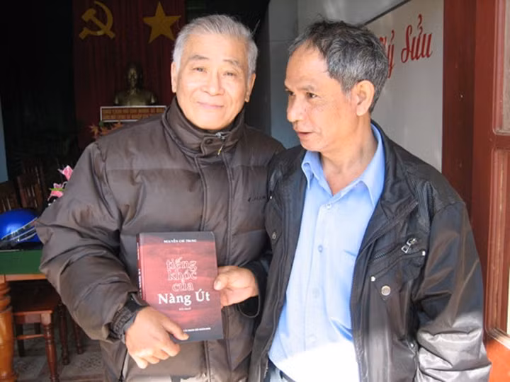 Nhà văn Nguyễn Chí Trung (bên trái) giao lưu, tặng bạn đọc tiểu thuyết Tiếng khóc của nàng Út.
