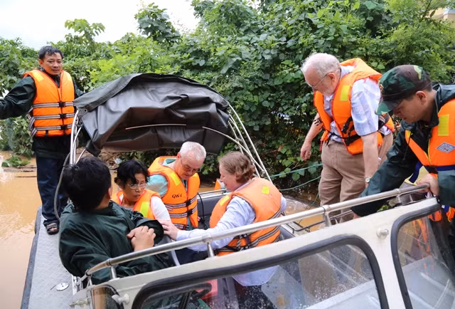 Hành khách trên chuyến tàu SE19, mắc kẹt tại Quảng Bình được đưa lên ca-nô trưa 15-10 đến nơi an toàn.
