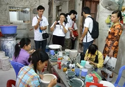 Khách du lịch tham quan một xưởng làm gốm tại làng nghề Bát Tràng.