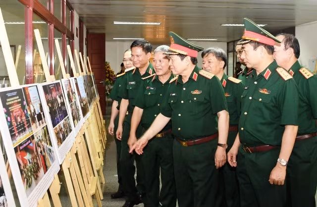 Đại tướng Ngô Xuân Lịch, Bộ trưởng Quốc phòng, cùng đại diện lãnh đạo Bộ Quốc phòng tham quan một số hình ảnh của cán bộ, phóng viên các cơ quan báo chí quân đội tác nghiệp tại các đơn vị, địa phương.
