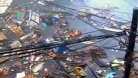 Các mảnh vỡ trôi nổi trên một con phố bị ngập lụt trong khi bão Haiyan tàn phá thành phố Tacloban ngày 8-11. (Ảnh: Reuters)