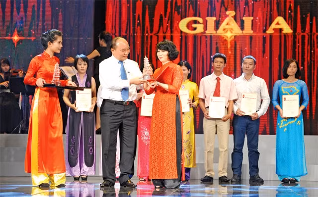 Nhóm tác giả Nhân Dân hằng tháng nhận giải A Báo chí quốc gia năm 2014. Ảnh | Trần Hải
