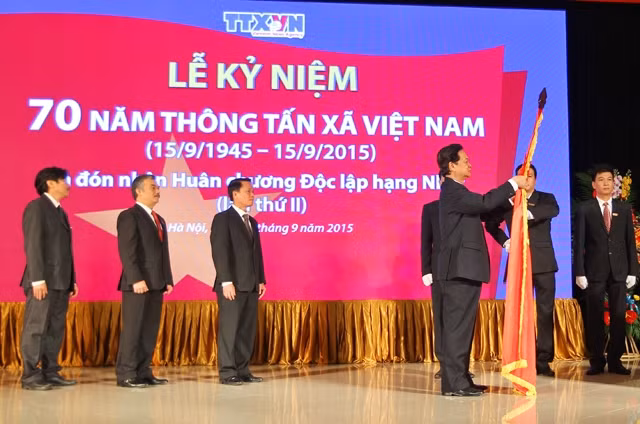 Thủ tướng Nguyễn Tấn Dũng gắn Huân chương Độc lập hạng nhất lên Cờ truyền thống của Thông tấn xã Việt Nam.