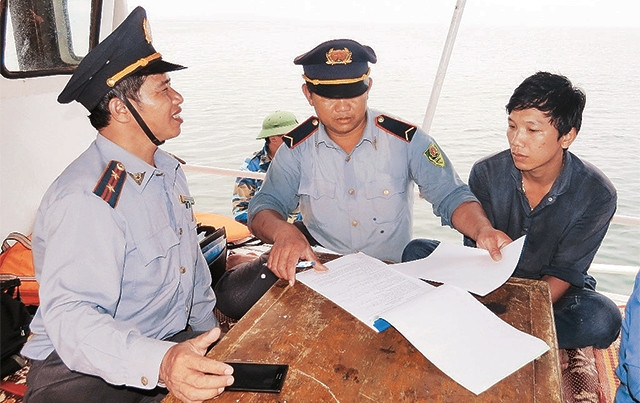 Cán bộ kiểm ngư tỉnh Quảng Bình lập biên bản xử phạt hành chính chủ tàu cá vi phạm trên vùng biển gần bờ.