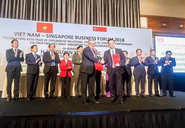 Ông Phạm Quang Dũng, Tổng Giám đốc Ngân hàng TMCP Ngoại thương Vietcombank (bên phải) và ông Ho Meng Kit, Giám đốc điều hành của SBF ký kết thỏa thuận hợp tác giữa hai bên.