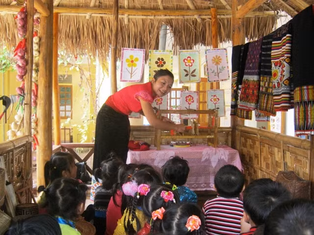 Cô giáo điểm trường lẻ tại bản Lũng, thuộc Trường mầm non Tam Thái giới thiệu mô hình khung dệt thổ cẩm tự làm cho học sinh.