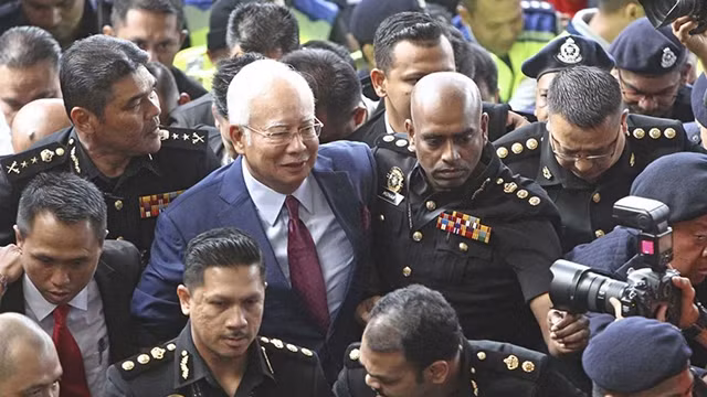 Cảnh sát đưa ông Najib Razak tới phiên xét xử ngày 4-7. Ảnh: AP