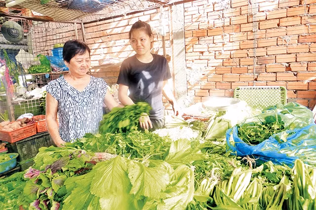 Bà Võ Thị Kính (người bên trái) trò chuyện với một hộ kinh doanh.