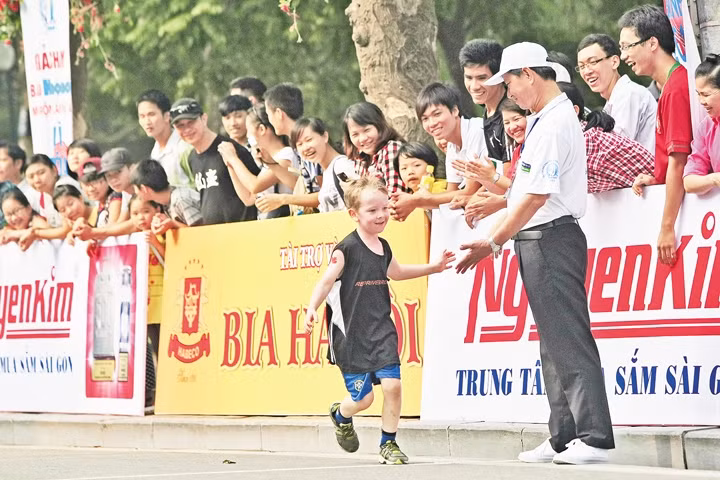 Em bé nước ngoài được chào đón và cổ vũ khi tham gia một sự kiện thể thao quốc tế tại Hà Nội. Ảnh: Minh Lê