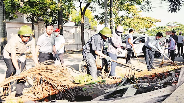 Cán bộ và nhân dân huyện Thanh Trì ra quân dọn vệ sinh môi trường tại xã Tân Triều. Ảnh: HOÀNG MINH