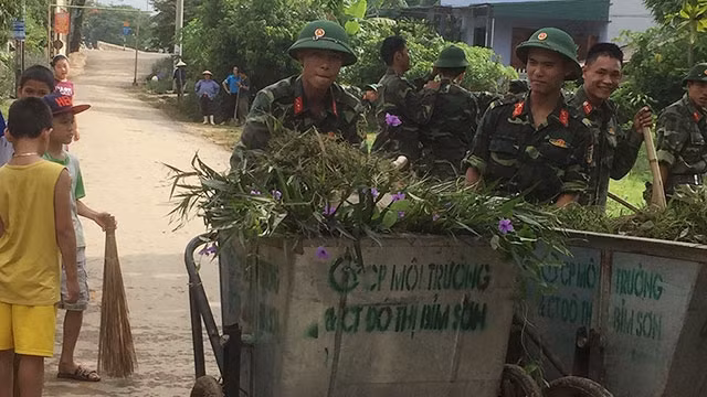 Bộ đội giúp dân dọn dẹp đường sạch đẹp.