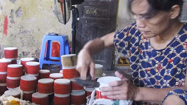 Nghệ nhân Nguyễn Thị Lành tán đinh cho trống.