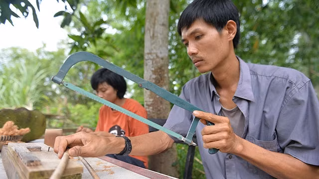 Trần Minh Tiến đang làm ống hút từ tre.