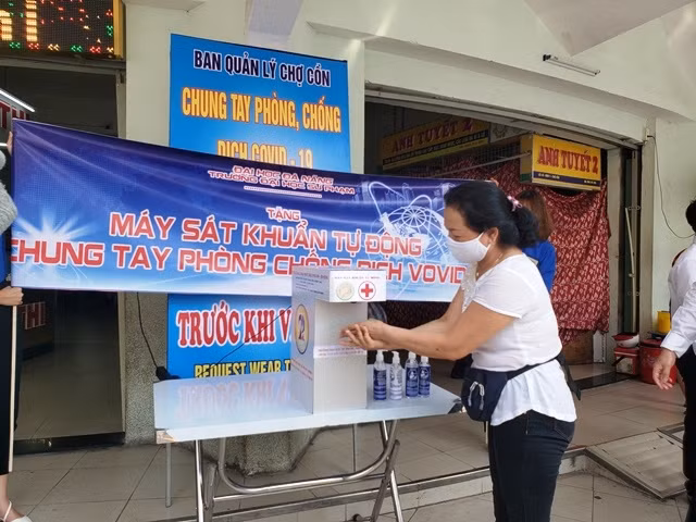 Tiểu thương chợ Cồn sử dụng máy rửa tay sát khuẩn phòng, chống dịch Covid-19.