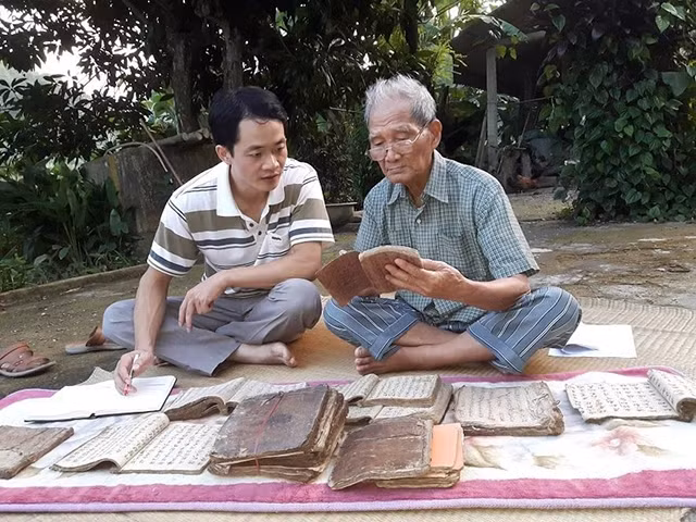Nhà văn Nông Viết Toại (bên phải) là một trong số ít người có thể đọc và hiểu thư tịch cổ tại Bắc Cạn.