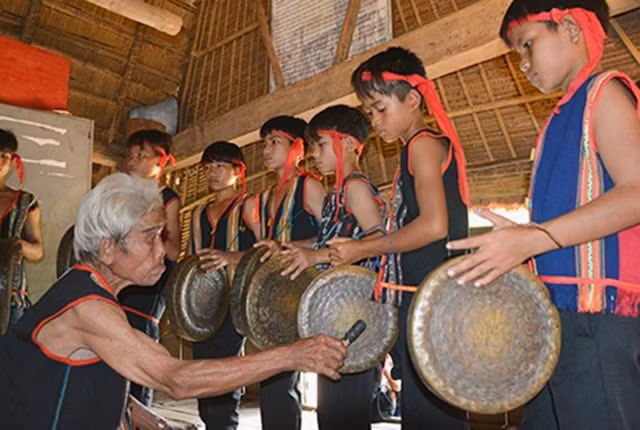 Nghệ nhân hướng dẫn cách sử dụng cồng chiêng cho lớp trẻ ở Kon Tum.
