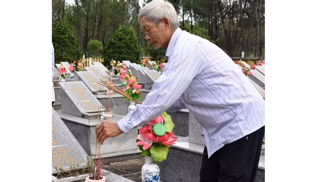 Dâng hương lên mộ liệt sĩ là công việc hằng ngày của người quản trang Lê Văn Cư.