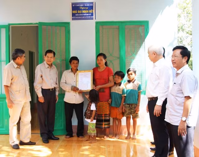 Nguyên Chủ tịch nước Nguyễn Minh Triết (thứ hai từ trái qua) tặng nhà đại đoàn kết cho gia đình anh Điểu Hùng.