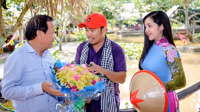 Anh Phong tặng hoa thắt bằng lá dừa cho đại diện khách du lịch.