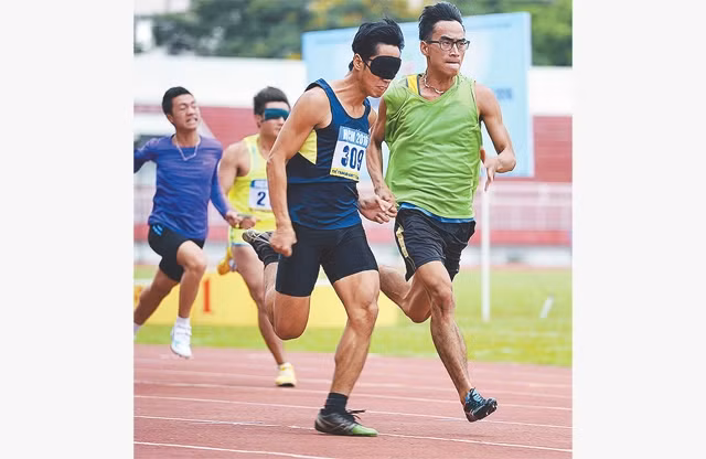Thi chạy 100 m có người dẫn tại một Giải thể thao dành cho người khuyết tật Việt Nam. Ảnh: anhthethao.com