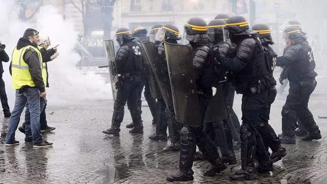 Người biểu tình đụng độ với cảnh sát trên đường phố Paris. Ảnh: CNN