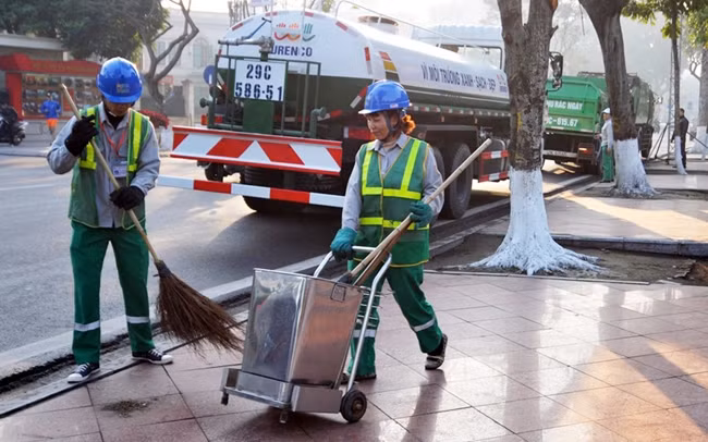 Công nhân Công ty Môi trường đô thị Hà Nội dọn vệ sinh trên tuyến đường Điện Biên Phủ. Ảnh: NGUYỄN TUẤN