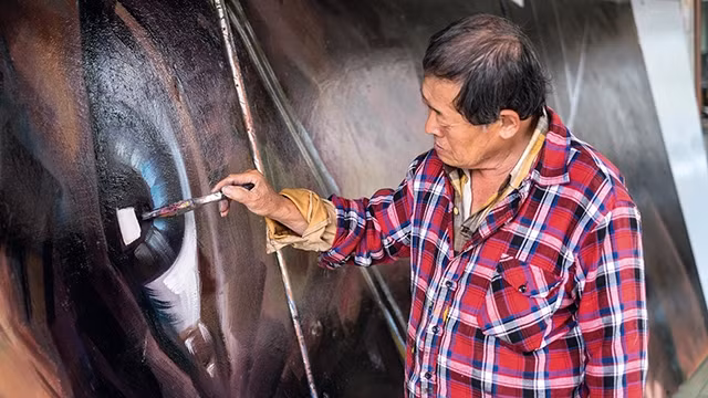Ông Yan Jhen-Fa vẽ áp-phích cho một bộ phim. Ảnh: NSPP