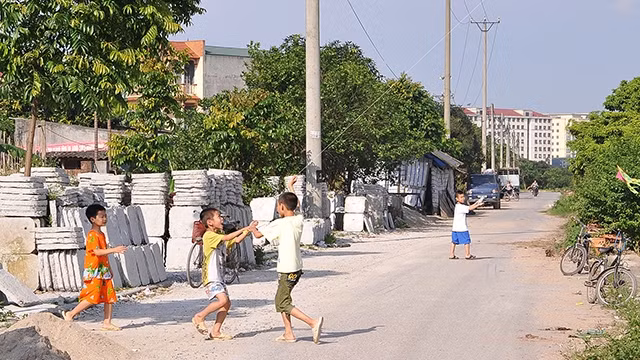 Trẻ em thiếu sân chơi khi làng bị đô thị hóa. Ảnh: NAM HẢI