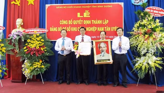 Phó Bí thư Tỉnh ủy Bình Dương Nguyễn Hữu Từ (bìa trái) trao Quyết định thành lập Đảng bộ cơ sở KCN Nam Tân Uyên.
