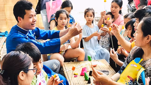 Nghệ nhân Đặng Văn Hậu đang hướng dẫn các em nhỏ nặn tò he.