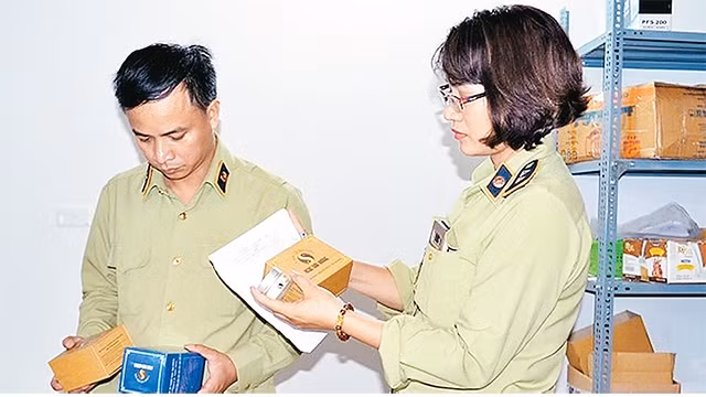 Lực lượng chức năng thu giữ các sản phẩm mỹ phẩm, thực phẩm chức năng không rõ nguồn gốc tại ngõ 9, phố Hoàng Cầu (Ðống Ða). Ảnh: LÊ TRUNG ANH