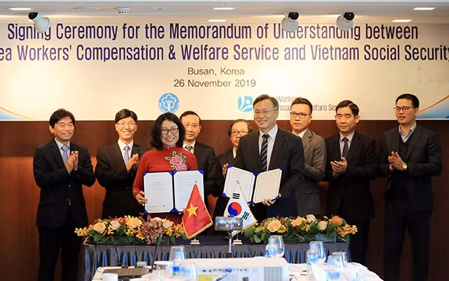 Tổng Giám đốc Bảo hiểm xã hội Việt Nam Nguyễn Thị Minh và Chủ tịch KCOMWEL Shim Kyung Woo ký Bản ghi nhớ hợp tác.