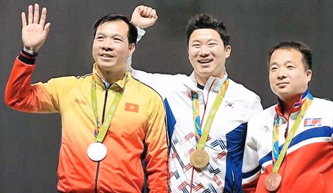 Hoàng Xuân Vinh (bên trái) trên bục nhận huy chương.