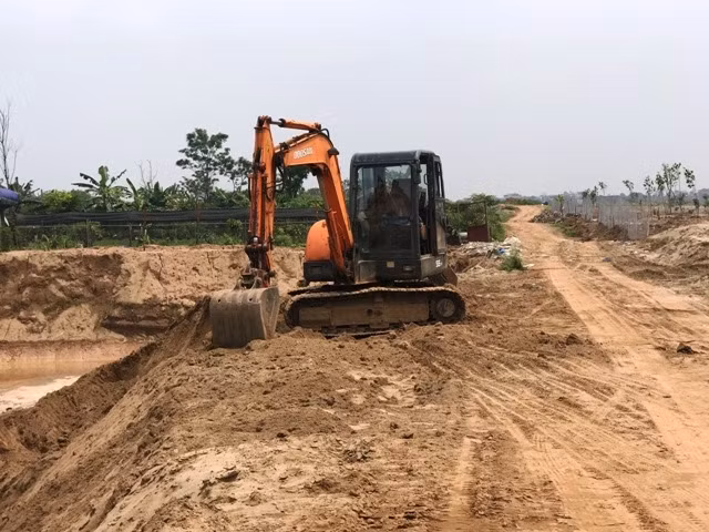 Máy xúc đào đất, cát ở bãi bồi sông Hồng.