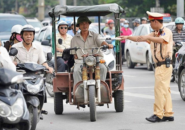 Lực lượng CSGT tiến hành kiểm tra một chiếc xe ba bánh đang lưu thông trên đường.
