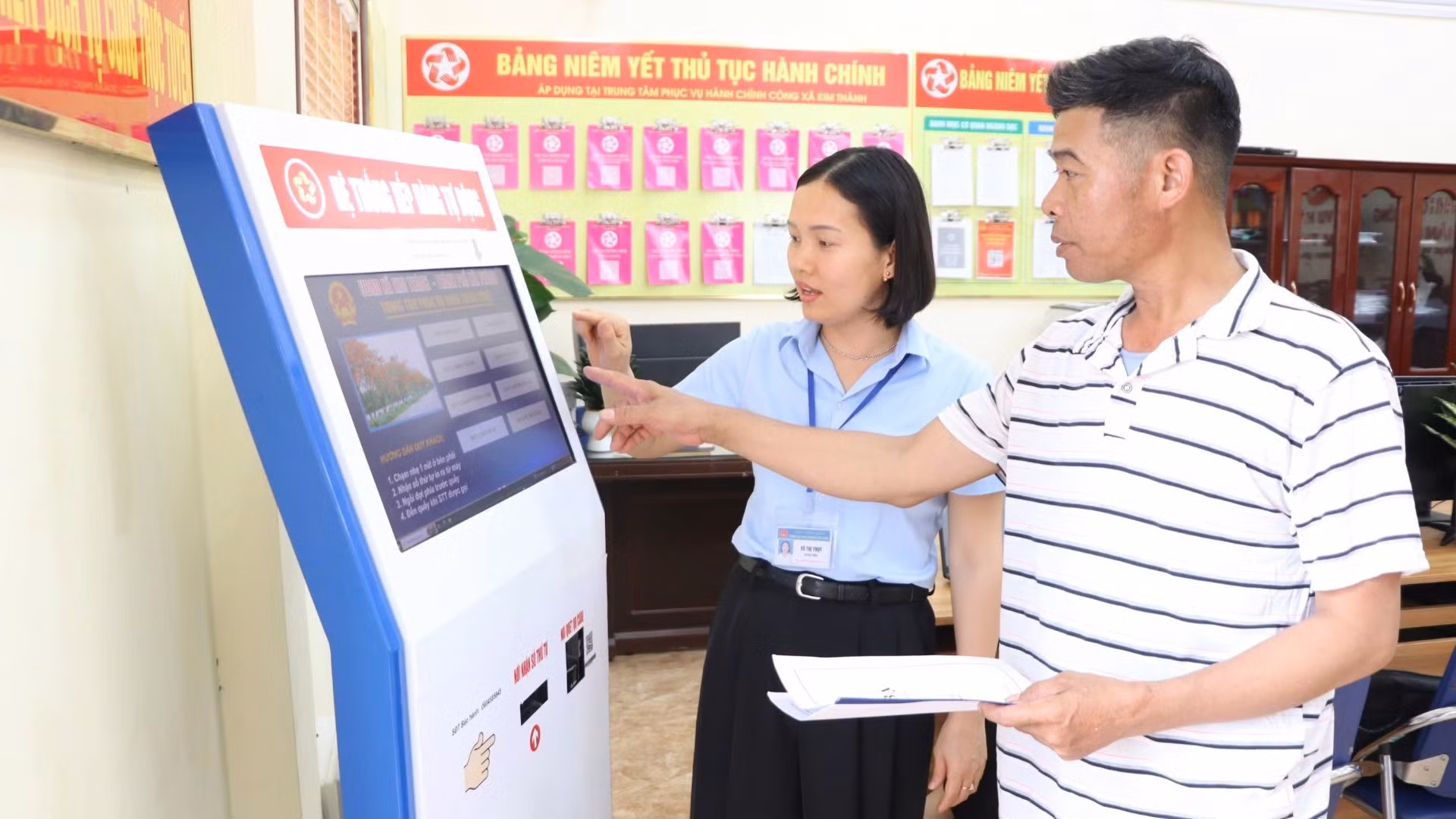 Công chức Trung tâm Phục vụ hành chính công xã Kim Thành, thành phố Hải Phòng, hướng dẫn người dân làm thủ tục hành chính. (Ảnh: TTXVN)