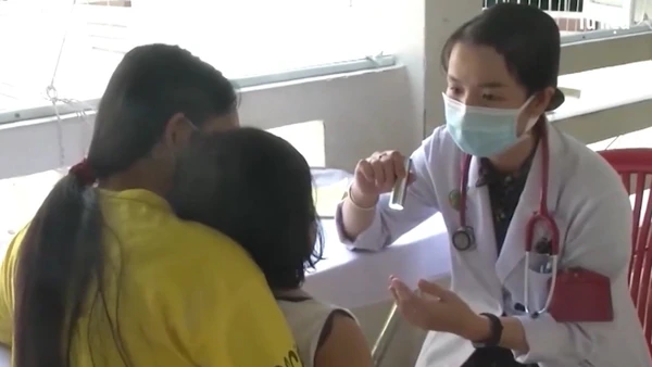 Bác sĩ khám cho bệnh nhi mắc tay chân miệng. 