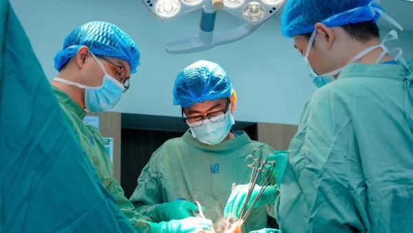 Bác sĩ chuyên khoa II Nguyễn Triệu Vũ, Trưởng khoa Tuyến vú, Bệnh viện Đại học Y Dược Thành phố Hồ Chí Minh và ê-kíp phẫu thuật cho bệnh nhân. 