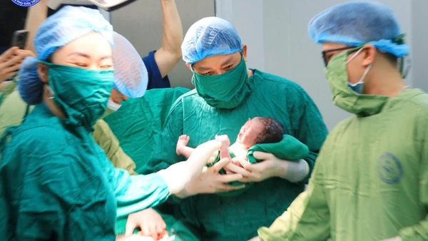 Giáo sư, Tiến sĩ Nguyễn Duy Ánh, Giám đốc Bệnh viện Phụ sản Trung ương thực hiện cắt dây rốn chậm cho em bé. 
