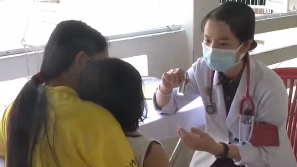 Bác sĩ khám cho bệnh nhi mắc tay chân miệng.