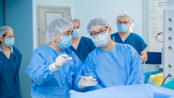Phó Giáo sư, Tiến sĩ Phạm Văn Bình trao đổi với đồng nghiệp trong ca phẫu thuật.