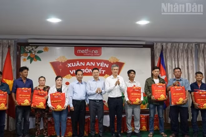 Đại sứ Việt Nam tại Campuchia Nguyễn Minh Vũ cùng đại diện Ban tổ chức trao tặng quà Tết cho bà con gốc Việt có hoàn cảnh khó khăn. (Ảnh: ĐINH TRƯỜNG)