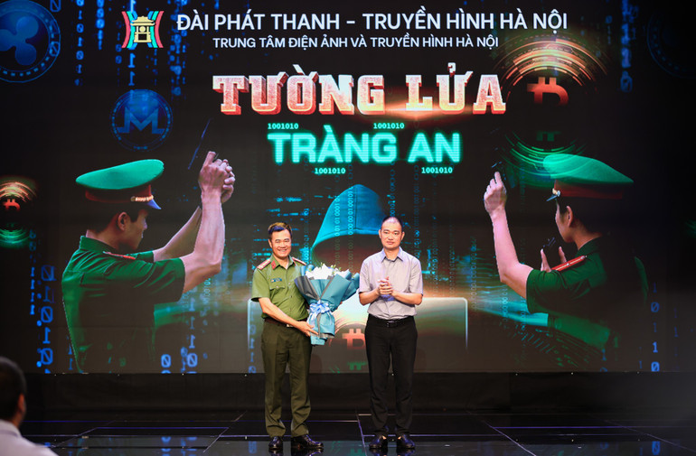 Đại diện lãnh đạo Công an thành phố Hà Nội tặng hoa chúc mừng đại diện lãnh đạo Đài Phát thanh-Truyền hình Hà Nội phụ trách làm phim. tl3.jpg